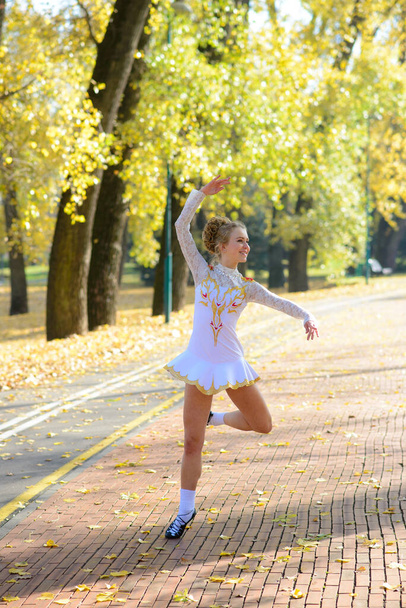 Балерина танцует в природном парке среди осенних листьев. - Фото, изображение
