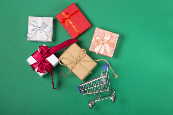 Gift boxes lie in a shopping basket. Gift shopping concept, online store - Foto, Bild