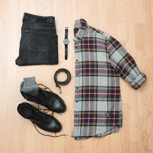 ρούχα ενός αγοριού που ετοιμάζεται να ντυθεί το χειμώνα ή το φθινόπωρο με μπότες πουκάμισο και γυαλιά - Φωτογραφία, εικόνα