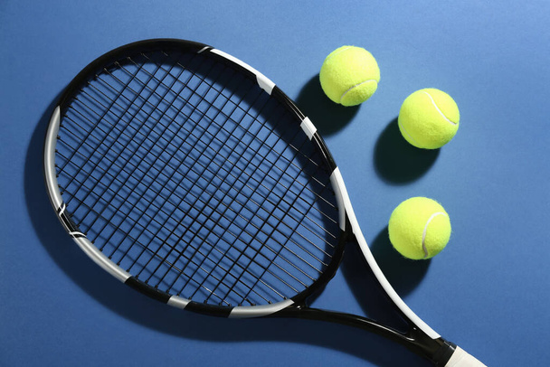 Tennis racket and balls on blue background, flat lay. Sports equipment - Foto, Imagen