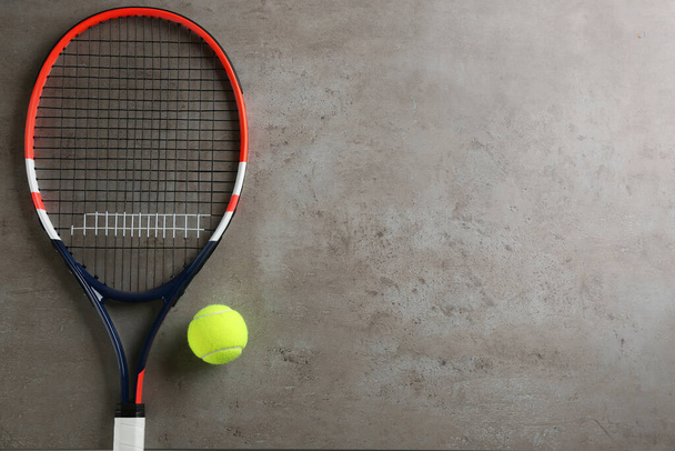 Tennis racket and ball on grey table, flat lay. Space for text - Foto, Imagen