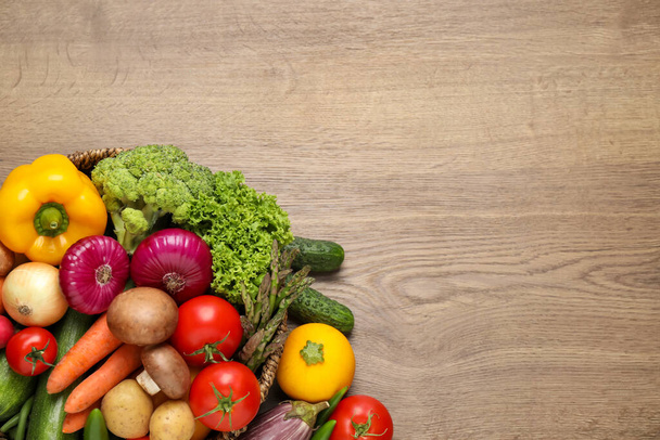 Different fresh vegetables on wooden table, flat lay. Space for text - Foto, Imagem