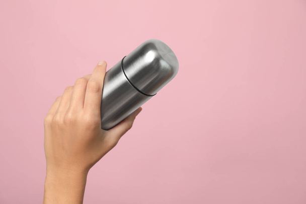 Woman holding modern thermos on pink background, closeup. Space for text - Fotoğraf, Görsel