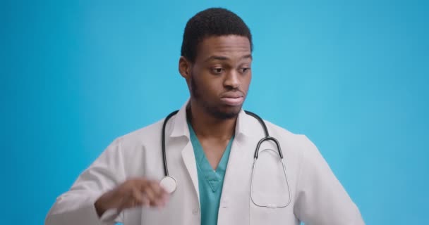 Portrait studio de médecin afro-américain déçu se grattant la tête dans l'incrédulité, n'a aucune idée de quoi faire - Séquence, vidéo