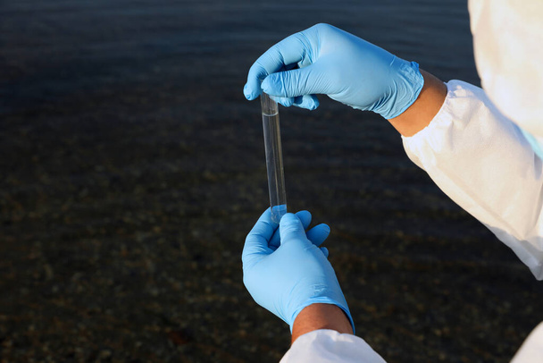 Scientist with test tube taking sample from river for analysis, closeup - Valokuva, kuva