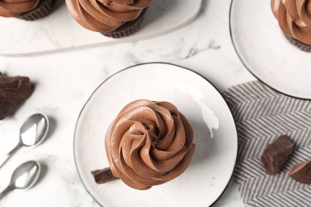Delicious fresh chocolate cupcake on white marble table, flat lay - Фото, изображение