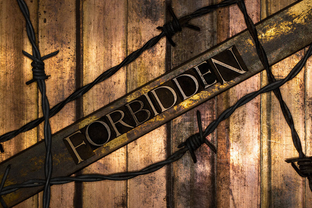 Forbidden text over barbed wire on grunge bronze with textured copper and gold background - Photo, Image