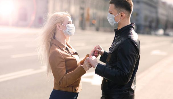 Young couple in masks on city street. Isolation, quarantine. - Photo, Image