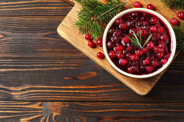 Cranberry sauce, and fir tree branches on wooden table, top view. Space for text - Foto, afbeelding