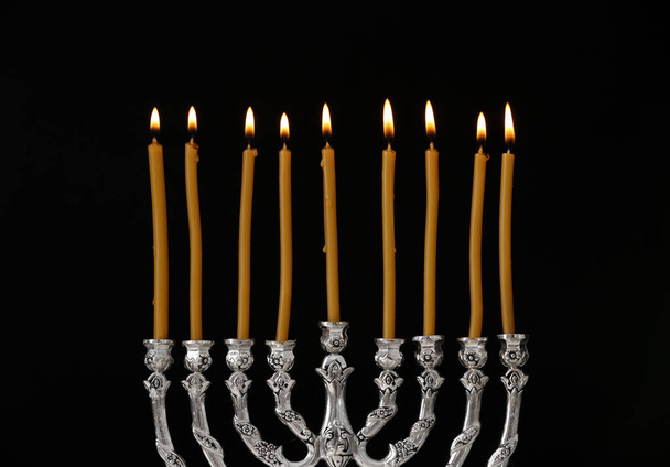 Silver menorah with burning candles against black background. Hanukkah celebration - Photo, Image