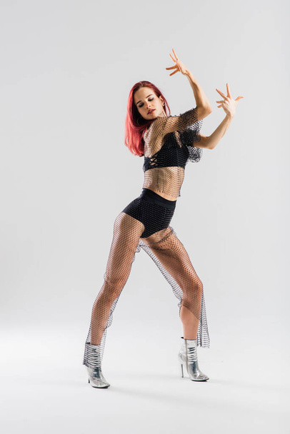 Σέξι κοκκινομάλλα χορεύτρια που δείχνει το όμορφο σώμα της - Φωτογραφία, εικόνα