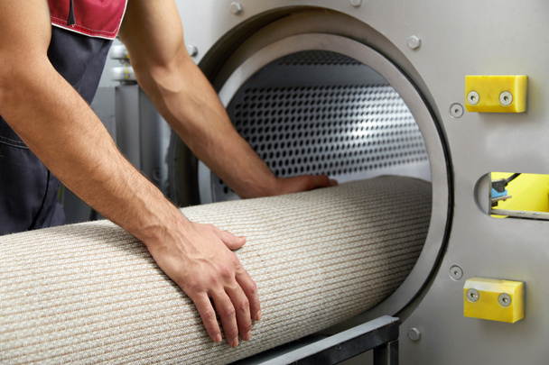 Der Mensch bedient eine Trockenmaschine zur Teppichreinigung. Professionelle Teppichreinigung - Foto, Bild