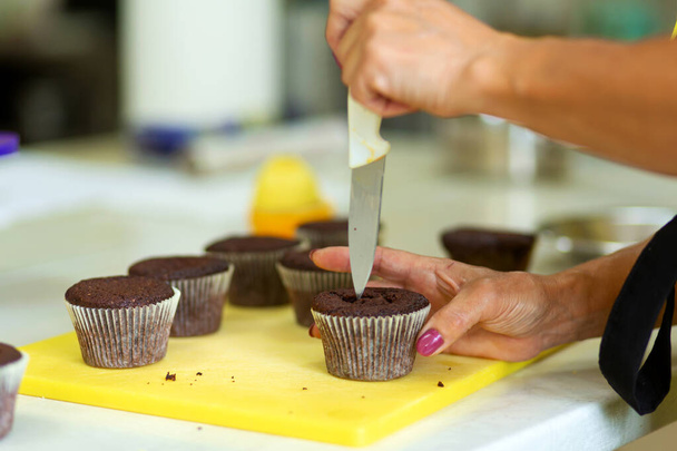 Процесс приготовления шоколадных кексов со сладким кремом. Создание тортов профессиональными кондитерами. - Фото, изображение