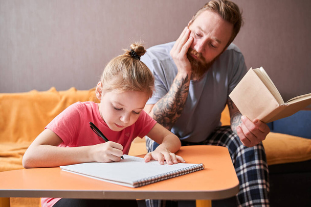 Father helping to little daughter with homework - Fotó, kép