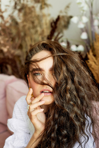 A girl of model appearance with long curly hair. An image of lightness and femininity - Fotoğraf, Görsel