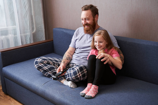 Father and his blonde pretty daughter watching tv - Fotoğraf, Görsel