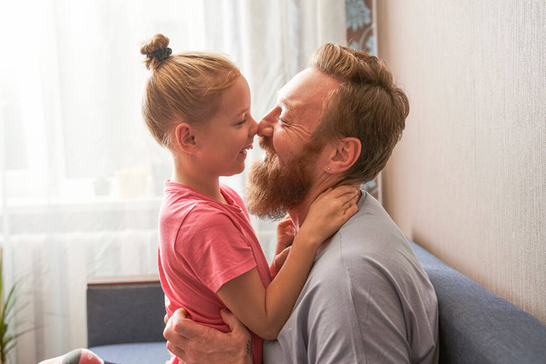 Daughter smiling and touching with nose with her father - Valokuva, kuva