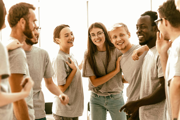 group of happy young people standing in a bright room - Foto, Bild