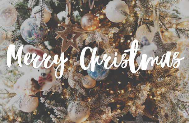 Mutlu Noeller tebrik kartı. Şık bir Noel ağacına, gümüş mücevherler ve şenlik odasında altın ışıklarla yazılmış mutlu Noeller mesajı. Mutlu tatiller, mevsimler selamlar - Fotoğraf, Görsel