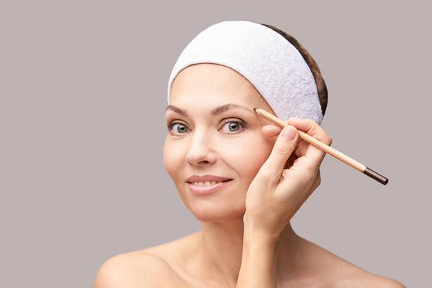 Beautician skin care. Face pencil make up. Facial treatment. Woman dermatology - 写真・画像