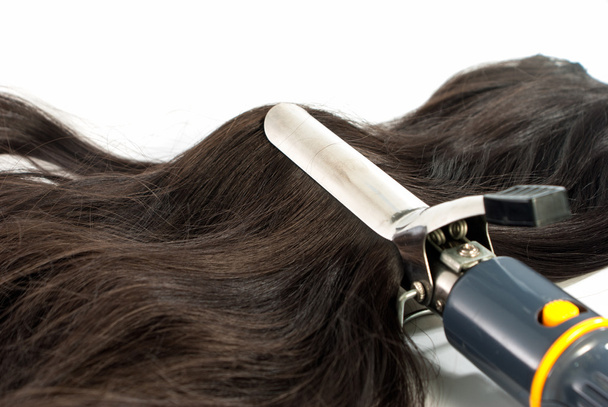 Fer à friser électrique et cheveux sur fond blanc
 - Photo, image