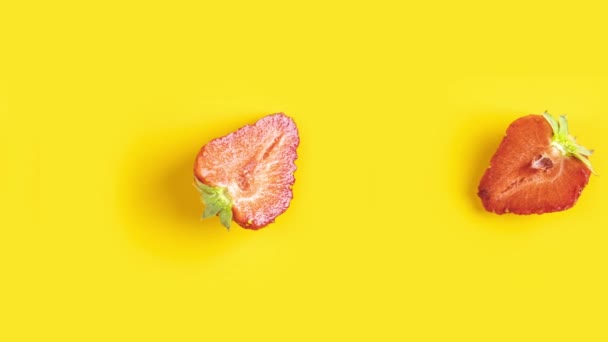 Muchas fresas rojas frescas cortadas animadas sobre un fondo amarillo. Comida en bucle sin fisuras, arte de diseño de movimiento mínimo con fruta - Metraje, vídeo