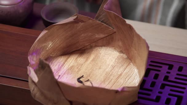 A folyamat, hogy nagy levelű teát öntenek egy speciális teásdobozba egy speciális állványra, amely egy fából készült asztalon áll.. - Felvétel, videó