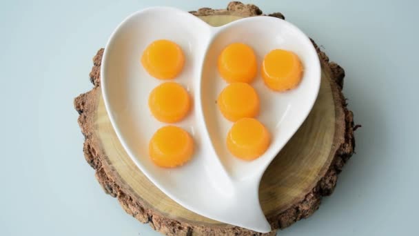 Quindins on a heart-shaped plate. Zoom in. Traditional Brazilian sweet. - Video, Çekim