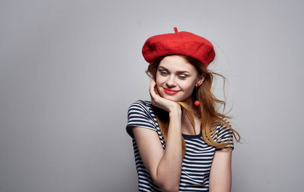 赤ベレー帽をかぶった女性の手に灰色の背景感情の肖像画 - 写真・画像