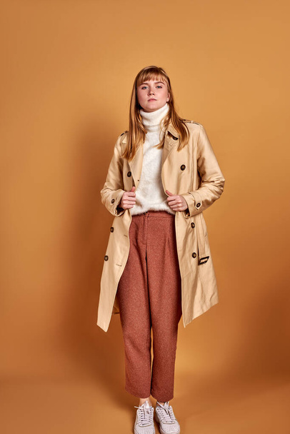 lady in coat posing isolated over brown background - Fotografie, Obrázek