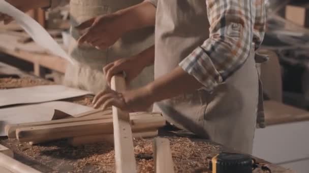 Keskiosa laukaus tunnistamaton poika ja aikuinen mies tekee puutyöt mittaus pala puuta tapeline kirvesmiehen työpaja - Materiaali, video