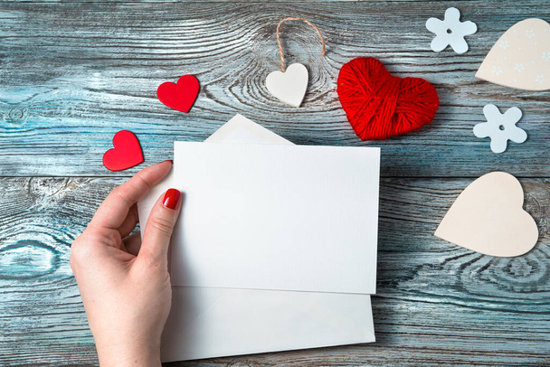Egy nő a kezében tart egy üres levelet romantikus háttérrel.. - Fotó, kép