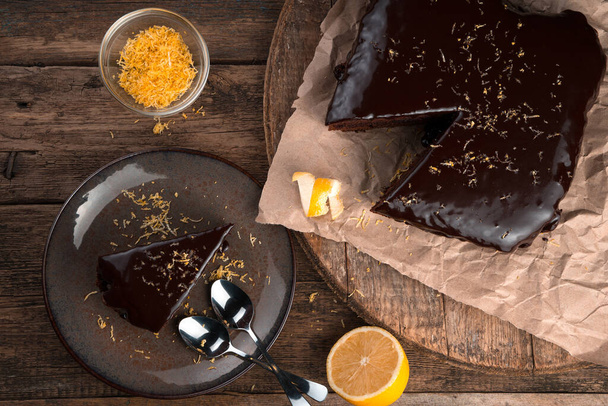 木の背景にレモンとゼストのチョコレートケーキと料理の背景. - 写真・画像