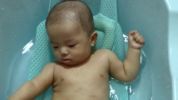Happy and adorable baby boy playing water during taking a bath - Footage, Video