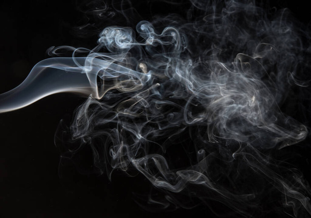 Абстрактні пуфи диму на чорному тлі
. - Фото, зображення
