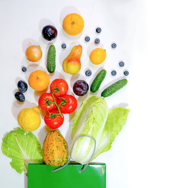Paper green bag with healthy food set on white background, copy space - 写真・画像