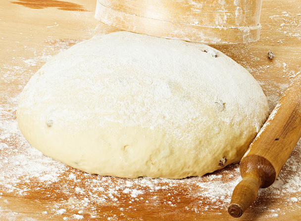 dough with rolling pin on floured table top view - Photo, Image
