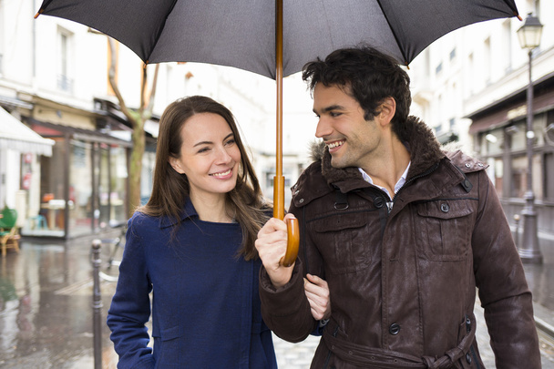Couple with umbrella walking under rain - Photo, Image
