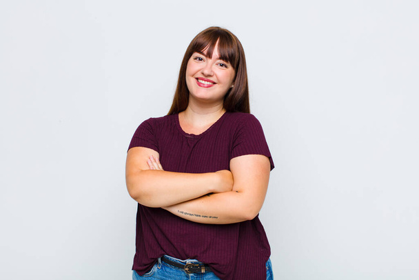 overweight woman laughing happily with arms crossed, with a relaxed, positive and satisfied pose - Photo, image