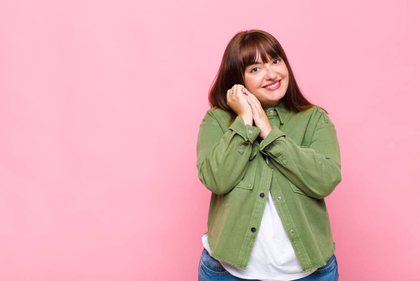 overweight woman feeling in love and looking cute, adorable and happy, smiling romantically with hands next to face - Fotoğraf, Görsel
