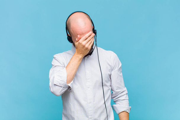 bald man looking stressed, ashamed or upset, with a headache, covering face with hand - Фото, зображення