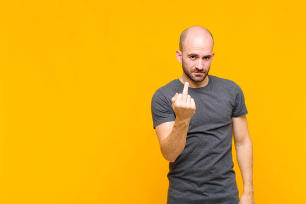 bald man feeling angry, annoyed, rebellious and aggressive, flipping the middle finger, fighting back - 写真・画像