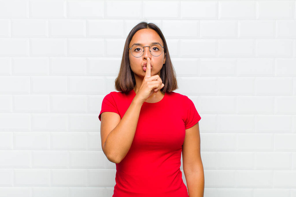 latin woman looking serious and cross with finger pressed to lips demanding silence or quiet, keeping a secret - Photo, Image