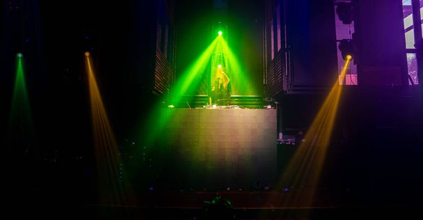 DJ lavalla disco-yökerhossa sekoittamassa tekno-musiikkia - Valokuva, kuva