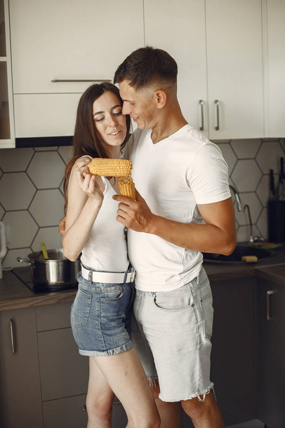 Beautiful couple spend time in a kitchen - 写真・画像