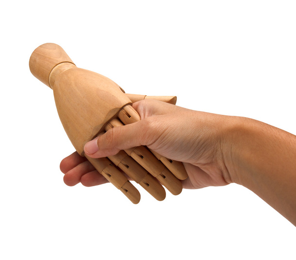 Handshake between a human hand and a wooden hand - 写真・画像
