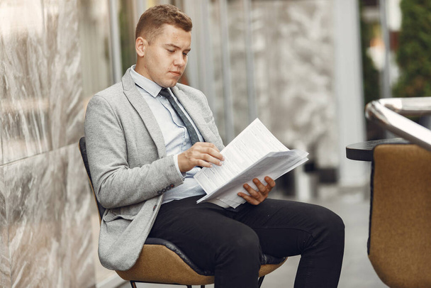 Businessman in a gray suit with a documents - Zdjęcie, obraz