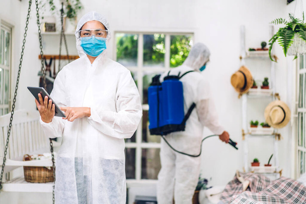 Professionelle Teams für Desinfektionshelfer in Schutzmaske und weißen Anzug Desinfektionsspray Reinigungsvirus für Hilfe Service töten Coronavirus bei Kunden zu Hause - Foto, Bild