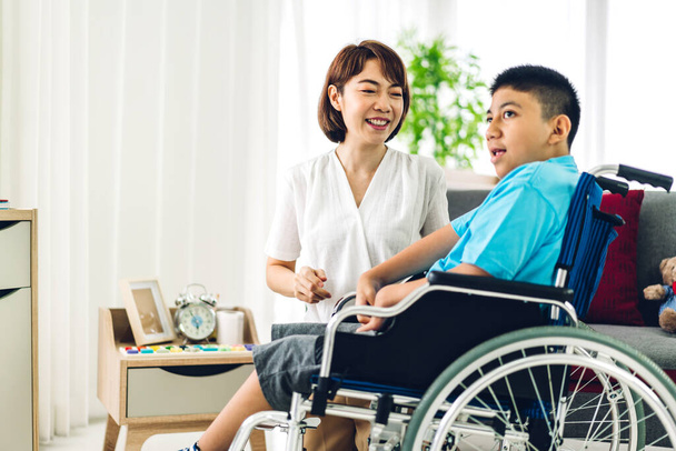 Retrato de fisioterapeuta asiática cuidadora ayudando y jugando con problemas especiales de salud del niño discapacitado haciendo ejercicios sentados en silla de ruedas en la clínica de rehabilitación.Concepto de cuidado de la discapacidad - Foto, imagen