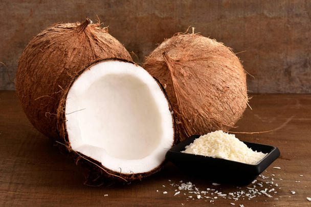 die Hälfte der Kokosnüsse auf einem hölzernen Hintergrund - Foto, Bild